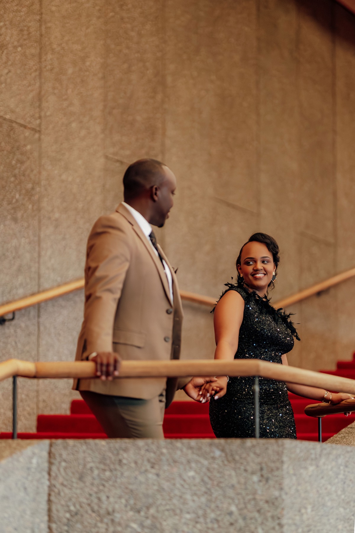 Hope and Arsene on a grand staircase, dressed for the evening
